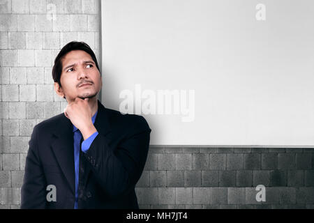 Young asian businessman thinking for solution with whiteboard on the background Stock Photo