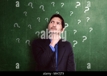 Thoughtful asian businessman having many questions in his head. Business concept Stock Photo