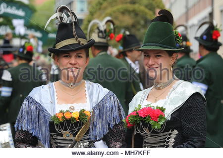 Two participants dressed in traditional costumes  smile for the camera before the start of the Oktoberfest parade in Munich Stock Photo