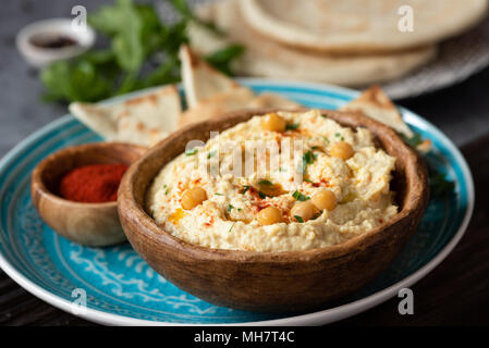 Traditional chickpea hummus in bowl, pita and paprika. Healthy vegan spread, arabic food. Selective focus. Stock Photo