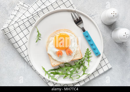 Cute funny breakfast for kids. Chicken shaped sandwich or toast on white plate. Food Art idea. Flat Lay. Table top view Stock Photo