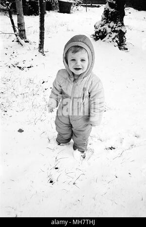 Eighteen month old baby boy in a snowsuit, Medstead, Alton, Hampshire, United Kingdom. Stock Photo
