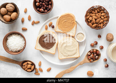 Nut butter and bread toast on white plate. Assorted nut butter spread on white toast bread. Healthy eating, vegan, vegetarian, healthy lifestyle, nutr Stock Photo