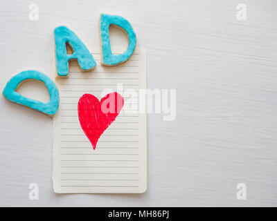 Postcard with painted red heart and word DAD on white, isolated background. Congratulation to the father. Preparation for Father's Day Stock Photo