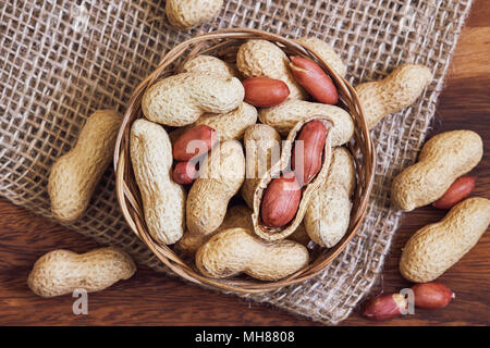Dry roasted peanuts (salted, in shell) in bowl. Top view Stock Photo