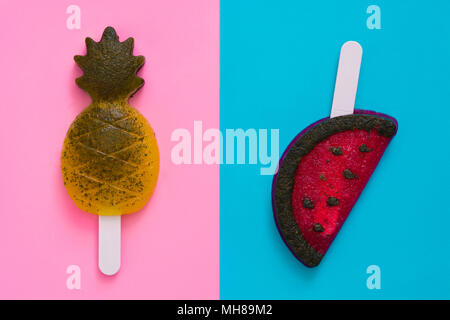 Pineapple and watermelon popsicles on pink and blue background. Top view Stock Photo