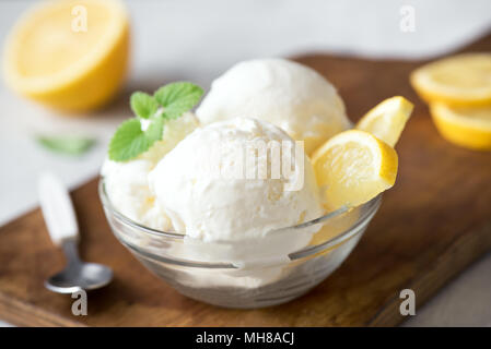 Lemon Ice Cream in bowl. Homemade citrus lemon ice cream with mint close up. Stock Photo