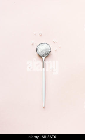 Sea salt on pink pastel background, top view. Stock Photo