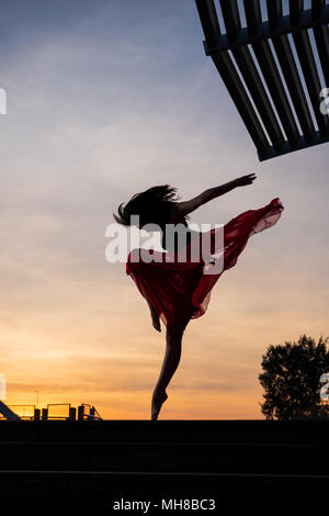 Elegant ballet dancer woman dancing ballet in the city of Singapore at sunrise Stock Photo