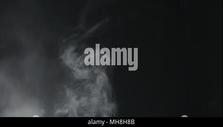 vapor steam rising over black background Stock Photo