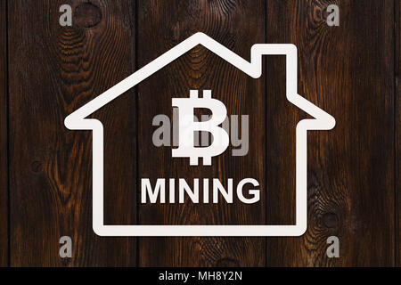 Paper house with bitcoin inside and text MINING. Abstract cryptocurrency concept with copyspace Stock Photo
