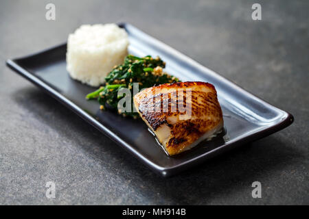 Miso marinated black cod with Japanese spinach salad gomaae Stock Photo