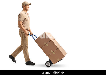 Full length profile shot of a delivery guy pushing a hand truck with boxes isolated on white background Stock Photo