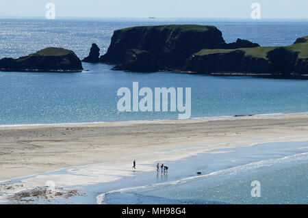 St Ninians Isle on a calm sunny day on the west side of the Shetland Isles with people on the beach Stock Photo