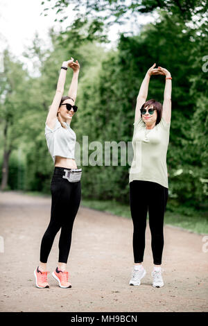 Two women exercising in the park Stock Photo