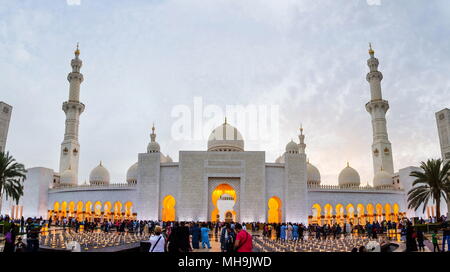 Abu Dhabi, UAE - April 27, 2018: Entrance view of Sheikh Zayed Grand Mosque, the largest mosque in the United Arab Emirates with many visitors in fron Stock Photo