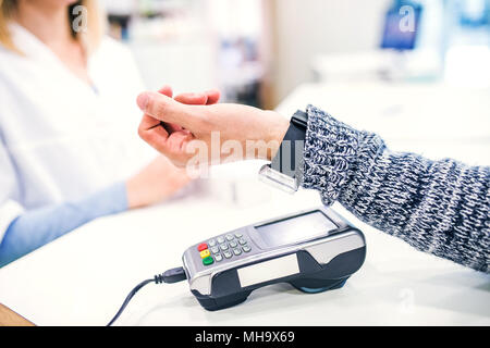 A customer making wireless or contactless payment using smartwatch. Stock Photo