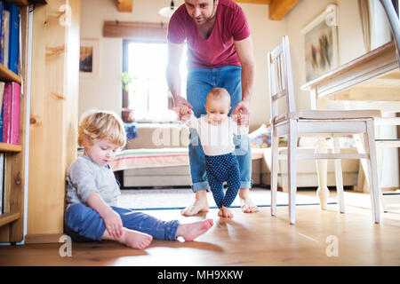 Father with two toddlers at home. First steps. Stock Photo