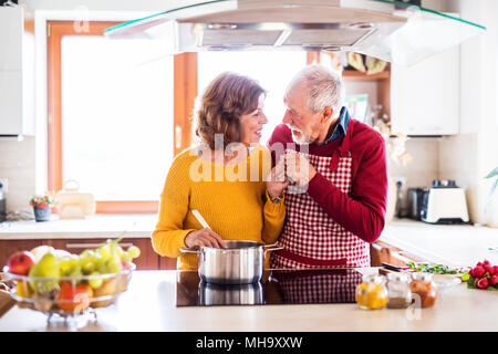 Happy senior couple cooking in the kitchen. Stock Photo