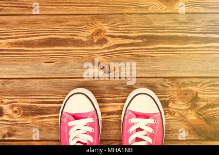 Pink sneakers on wooden texture Stock Photo