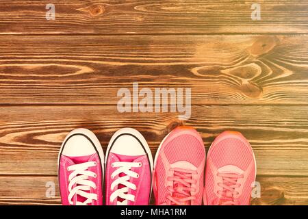Pink sneakers on wooden texture Stock Photo