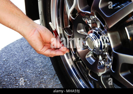 Montreal,Canada,18,April,2018.Checking air pressure with an air gauge on a hi-performance tire.Credit:Mario Beauregard/Alamy Live News Stock Photo