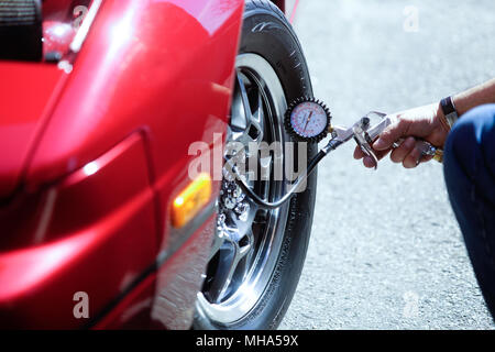 Montreal,Canada,18,April,2018.Checking air pressure with an air gauge on a hi-performance tire.Credit:Mario Beauregard/Alamy Live News Stock Photo