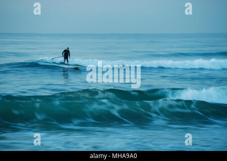 Durban, KwaZulu-Natal, South Africa, motion blur, adult man surfing a wave on stand up paddle board, Umhlanga Rocks beach Stock Photo
