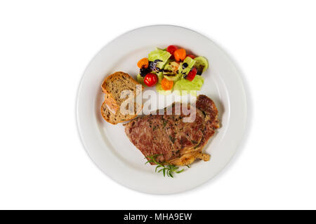 Ripened seasoned beef rump or striploin steak cooked on white plate with salad and home made bread. Top view isolated on white background. Stock Photo