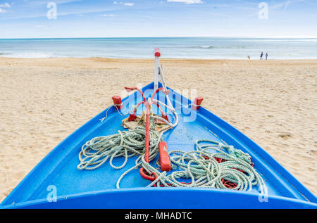 Blue, fishing boat on the sandy beach in Armacao de Pera, Algarve, Portugal Stock Photo