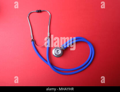 Medical blue stethoscope isolated on red background Stock Photo