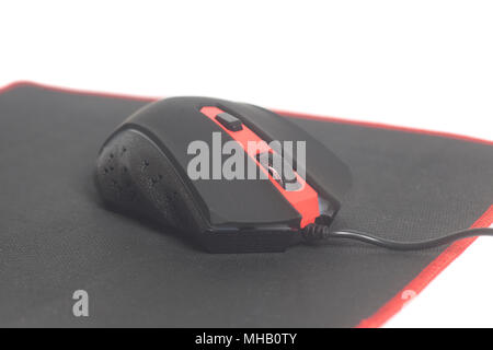 Computer modern gaming mouse on black mouse pad isolated on white background Stock Photo