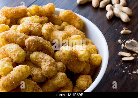 Peanut Chips on dark wooden surface. Fastfood. Stock Photo