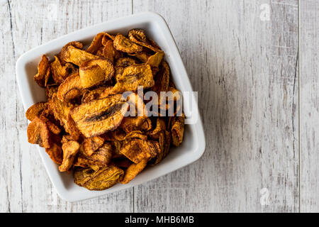 Dried Carrot Chips on white wooden surface. Organic Appetizer. Stock Photo