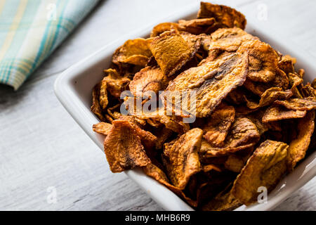 Dried Carrot Chips on white wooden surface. Organic Appetizer. Stock Photo