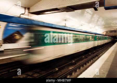 Blurry motion image of train approaching a station in subway station in Paris. Stock Photo