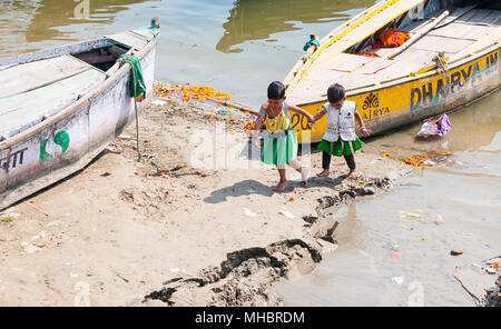 Two young girls holding hands and walking at the bank of river Ganges in Varanasi, the holy city of India Stock Photo