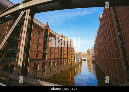 Famous landmark old Speicherstadt in Hamburg, build with red bricks. Bridge in low angle view