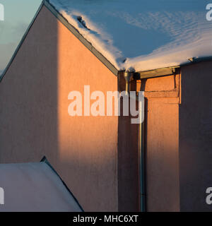 the symmetric house with a shadow from the sun and snow Stock Photo