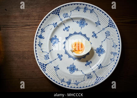Halved hard boiled egg on a blue and white plate Stock Photo