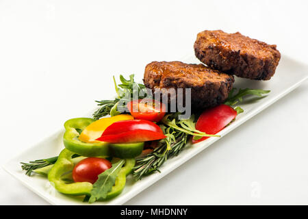 Fried cutlets and vegetable salad white plate on white background Stock Photo