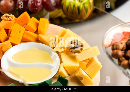 Pieces of cheese of different varieties with honey Stock Photo