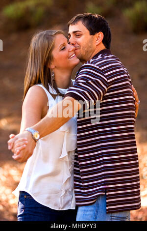A young couple in love strikes a mock dance pose as they playfully embrace each other. Stock Photo