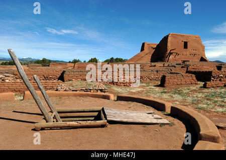 A ceremonial kiva stands near the adobe remains of a Spanish mission church at Pecos National Historic Park, site of the Pecos Pueblo, in New Mexico. Stock Photo