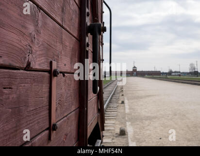 Main entrance to Auschwitz Birkenau Concentration Camp, showing cattle car used to bring victims to their death in the gas chambers in the foreground Stock Photo