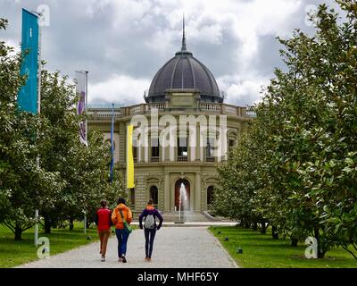 Three young women walk up the path towards the Ariana Ceramics and Glass Museum. Geneva, Switzerland. Stock Photo