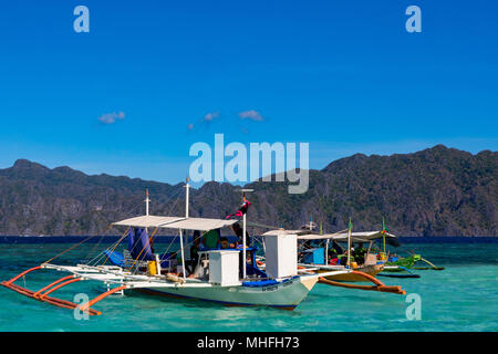 Coron Palawan Philippines April 13, 2018 Traditional outrigger tourist boats at CYC beach Stock Photo