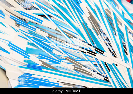 A closeup view of pile of shredded paper. The paper is white with blue lines. View is from above. Focus is in the center. Stock Photo