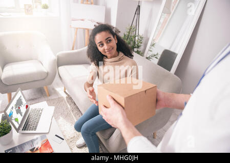 Joyful nice woman sitting on the sofa Stock Photo