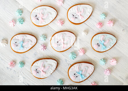Easter gingerbread glazed cookies, eggs form with rabbit, on white wooden background Stock Photo